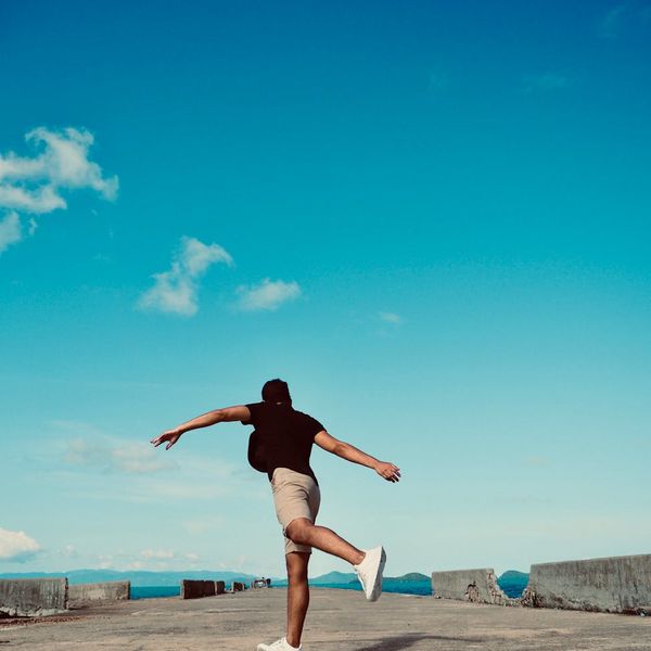 A silhouette of a person balancing on one leg during sunrise.